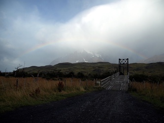 Schmale Holzbrücke mit Regenbogen