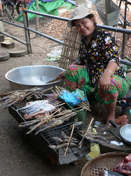 Marktfrau mit gebratenem Fisch