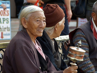 Alte Nepalesin mit Gebetsmühle